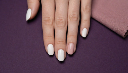 Hand showing gel polish peeling away from one nail beside healthy, adhered gel