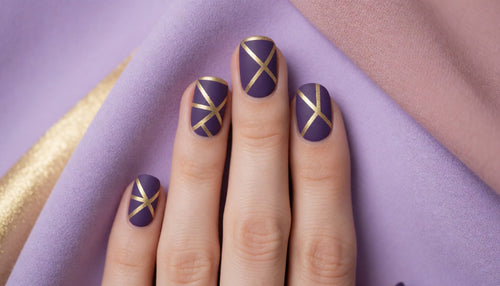 Hand with matte purple nails featuring sharp geometric gold striping tape lines